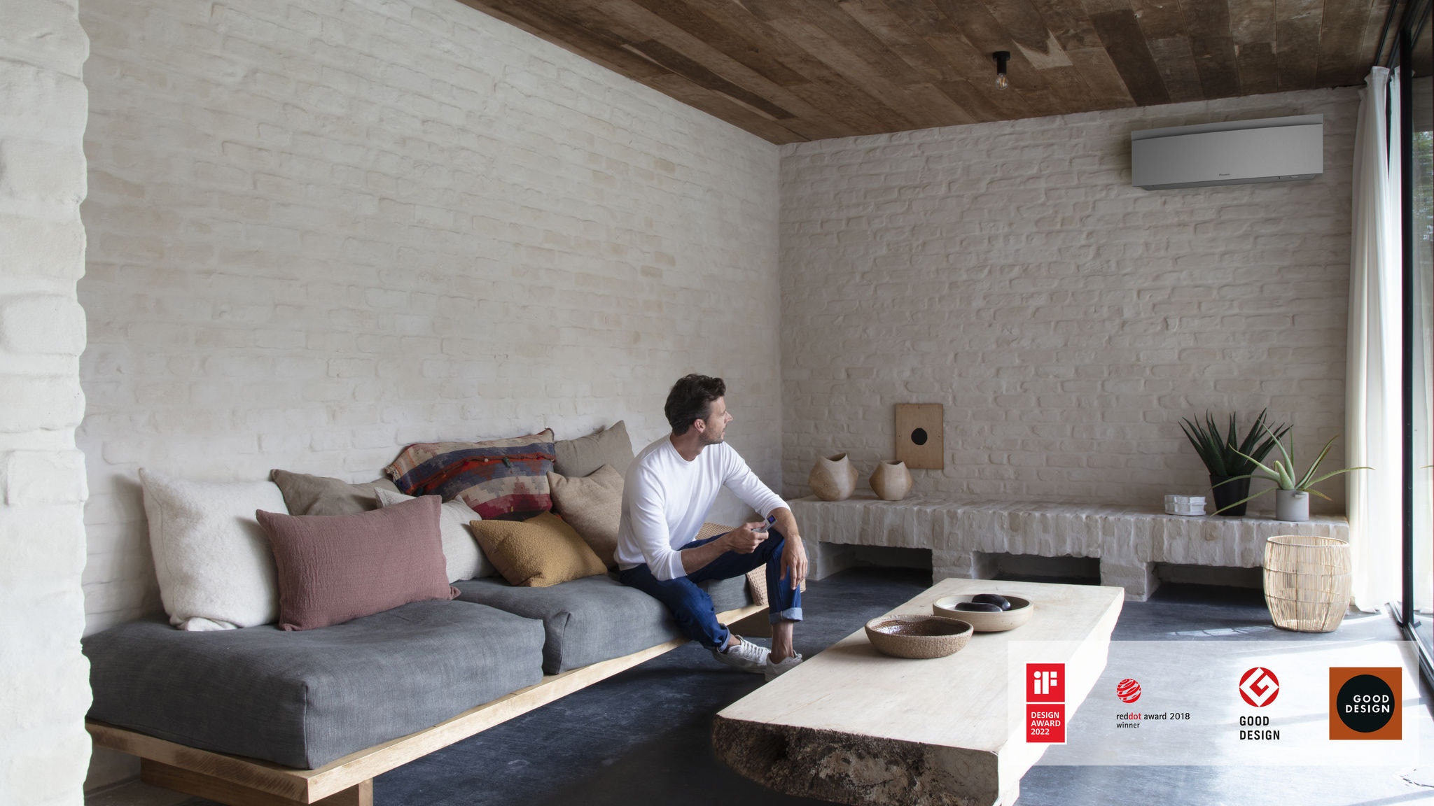 Homem controla o seu ar condicionado na sala de estar com um controlo remoto